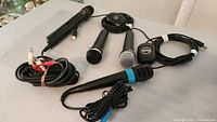 Four microphones laid out on a table with cables attached, showing their condition and types.