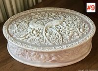 View of the dresser box top showing carved two birds and floral relief design.
