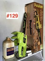 Poulan electric chain saw with original box and accessories including Husqvarna chain oil and replacement parts boxes
