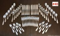 Overview of all 48 pieces laid out: 12 dinner forks, 12 dinner knives, 12 tablespoons, and 12 teaspoons arranged symmetrically.