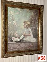 Framed print showing a young girl sitting on a stone ledge and looking at a bird on a flowering branch. The artwork is detailed and softly colored.