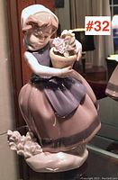 Front view of Lladró porcelain figurine showing girl holding basket of flowers, with label #32 on side