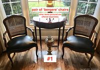 Two matching carved wood Bergere armchairs side by side in front of window