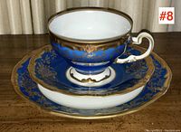 Full view of the porcelain tea trio including teacup, saucer, and tea plate with detailed cobalt blue and gold decoration.