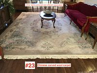 Full room view showing the rug under a coffee table between red sofas