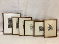 Six framed black and white etchings arranged from smallest to largest size, showing overall lot content with visible wooden gold-tone frames.