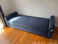 Full side view of assembled blue chenille daybed showing armrests and upholstery