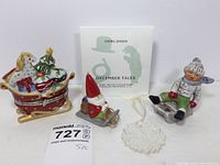Wide view of full lot with Villeroy & Boch sleigh trinket box, Georg Jensen ornaments, Goebel boy on sled, Margaret Furlong snowflake, and unmarked Santa on sled figurine.