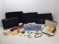 Overview photo of all items in the lot including jewelry, purses, trinket box, and perfume bottle.
