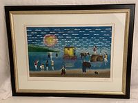 Full view of framed lithograph print showing a lakeside scene with people, animals, and a yellow wagon under a cloud-filled sky with sun.