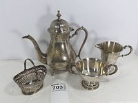 Photo showing full set with teapot, creamer, sugar bowl, basket and felt bags