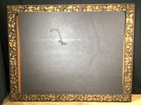 Front view of large mirror showing carved floral frame and reflective glass surface