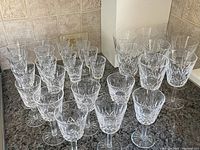 Thirty Waterford Lismore glasses arranged on countertop