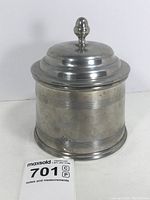 Front angled view of vintage pewter humidor showing lid and knob.