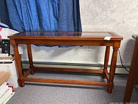 Wooden console/sofa table full view showing rectangular shape, wood finish, and glass top.