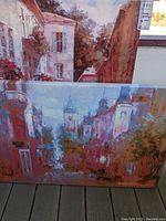 Two canvas prints shown stacked. The top print shows a street with buildings and red foliage.