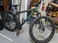Side profile of Mongoose Alder mountain bike showing frame, tires, and pedals