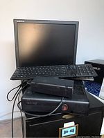 Xbox 360 console model 1439 with power supply on top, Dell keyboard and Samsung SyncMaster 710N monitor visible.
