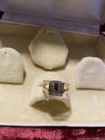 Front view of 10k gold ring with square semi-precious stone in jewelry box.