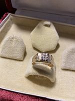 Front view of ring in display box showing diamond grid top.