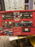 Front view of boxed Christmas train set showing locomotive, railcars, caboose, and original packaging with Christmas Express branding and safety warnings.