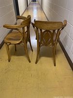 View of the two wooden chairs from behind showing bent wood structure and stamped markings.