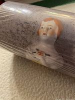 Rolled wallpaper showing a vintage-style portrait print under shrink wrap.