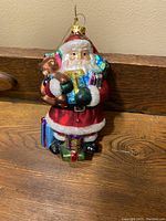 Front view of the vintage Santa Claus ornament showing details of the hand-painted decorations and overall size.