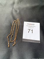 Full length view of 10K gold chain necklace laid flat on black background showing overall length and clasp