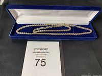 Full view of silver rope chain necklace in blue velvet-lined box