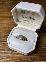 Ring displayed inside white hinged jewelry box labeled "The Watch Chalet, Napanee, Ont."