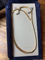 View of gold chain necklace displayed in a padded jewelry box