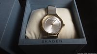 Front view of silver Skagen watch in original branded box on pillow.