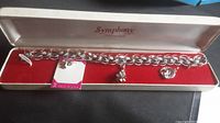 Full view of the Symphony sterling silver bracelet with three charms and original presentation box.