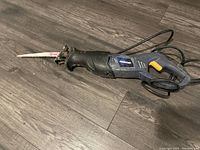 Full view of used Mastercraft sawsall with serrated blade attached on wood floor.