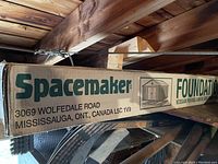 Long cardboard box with Spacemaker branding and identification of shed foundation kit, showing location Mississauga, ONT, Canada.