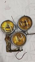 Three amber fog lights arranged closely with visible wiring and mounting bracket.