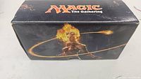 Front side of the Magic The Gathering box showing fire-themed female artwork and game logo.