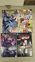 Four comic books: The Dark Knight Returns, Excalibur, Black Panther, and Harley Quinn 100-page Spectacular with visible covers.