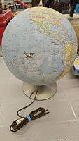 Full view of the vintage electric globe showing North and South America and the electric cord.