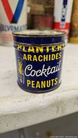 Photo of rare vintage Planters Cocktail Peanuts tin showing the front label and logo with visible age wear.