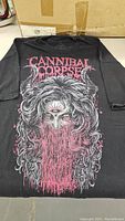 Front view of the black XL t-shirt showing Cannibal Corpse text and horror graphic.