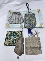 Top-down image showing all four vintage Victorian-style handbags placed on a mirrored tray (not included) showcasing their different shapes and materials.