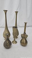 Group photo showing all six vintage brass vases of different shapes and sizes on white background.