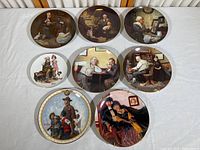 Eight Norman Rockwell collector plates arranged on a white surface, showing full designs, with four plates in top row, three in middle, one in front.