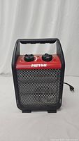 Front view of a Patton portable utility heater showing red top with two control knobs and black metal front grille.