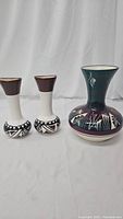 Full view of the set of three Southwestern pottery vases showing sizes and patterns
