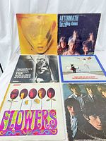 Six Rolling Stones vinyl LP records displayed side by side showing front covers, titles and artwork.