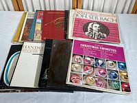 Photo of 18 vintage vinyl albums with worn covers including classical composers and Christmas-themed albums.