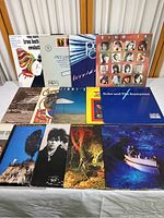 Set of 14 vintage vinyl albums arranged on table showcasing album covers and titles.